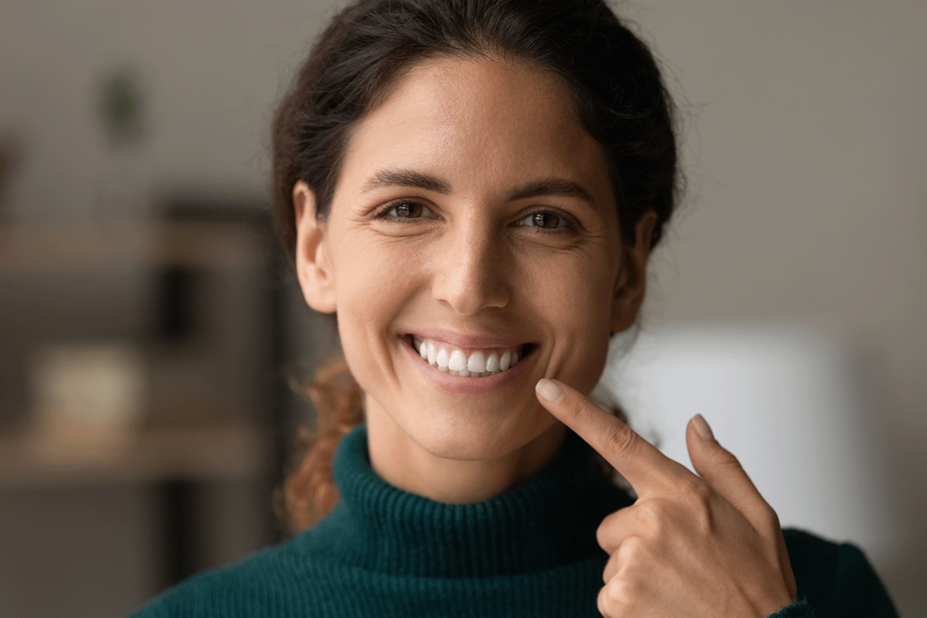 smiling woman pointing at smile