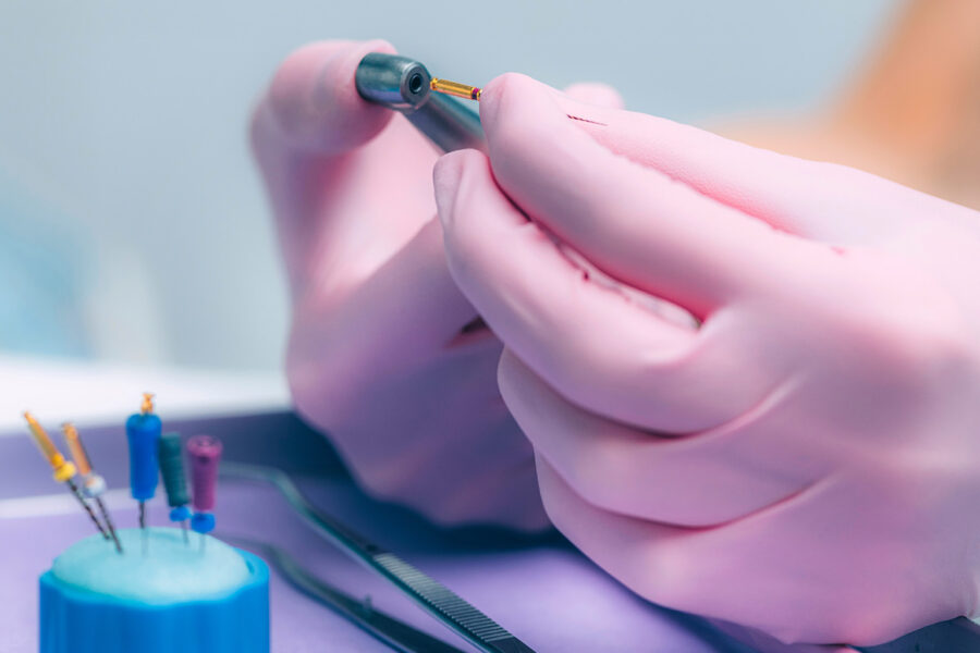 gloved hands holding dental tools