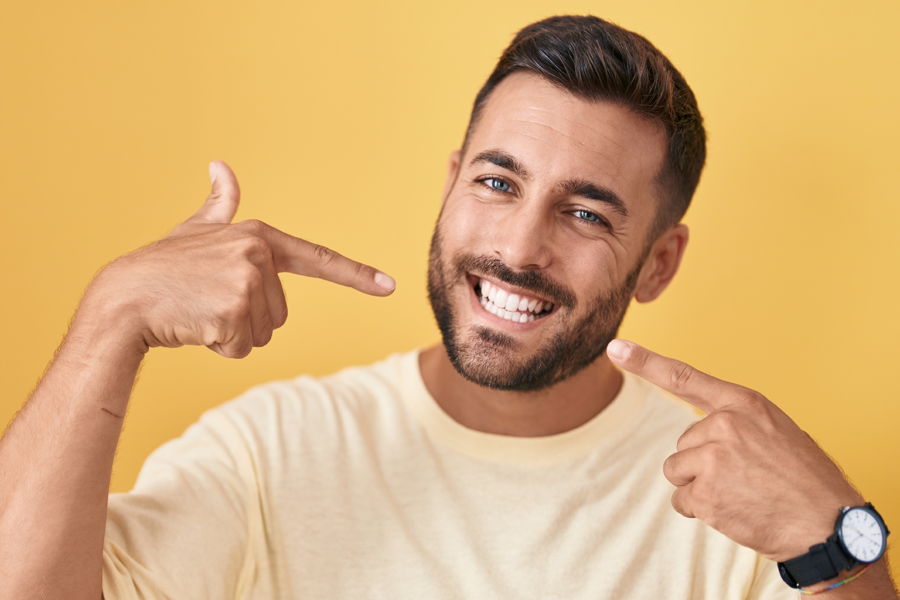 man pointing at his smile with both hands