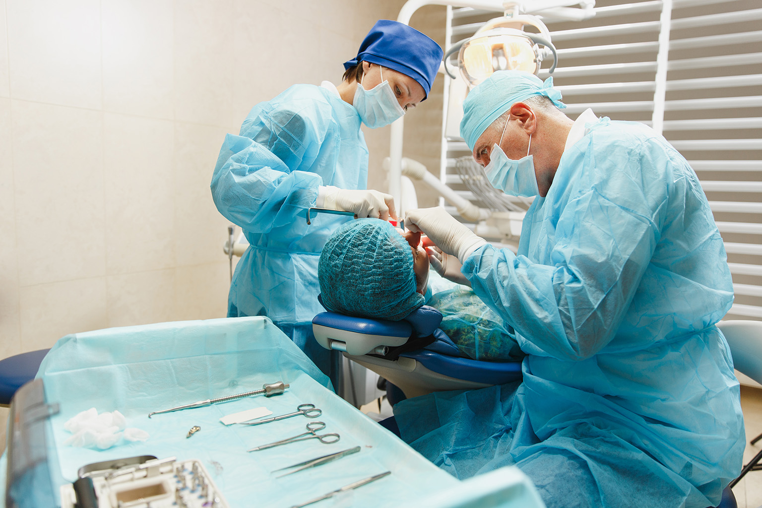 dental staff treating patient with dental tools in the foreground