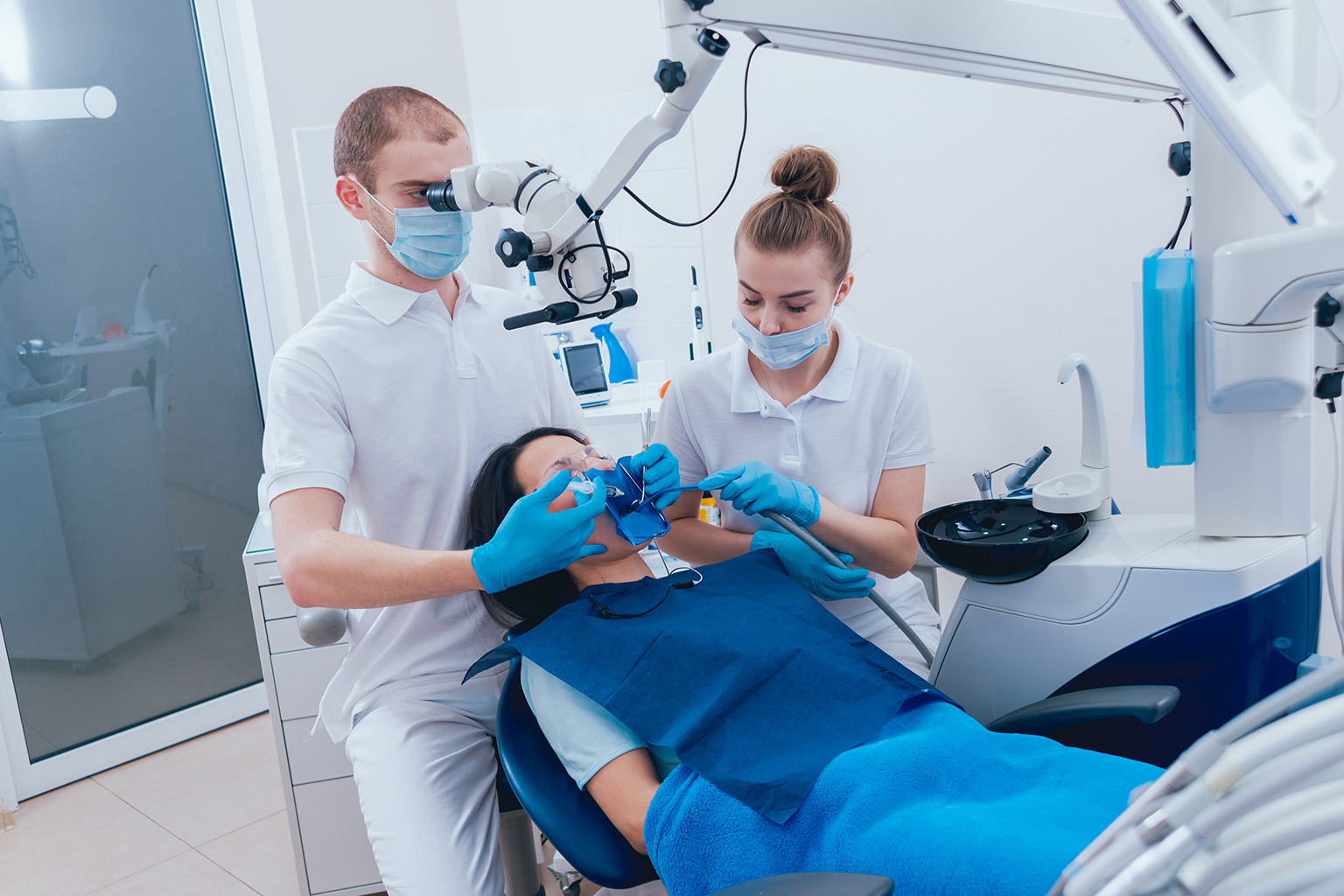 dentist and assistant performing root canal on patient