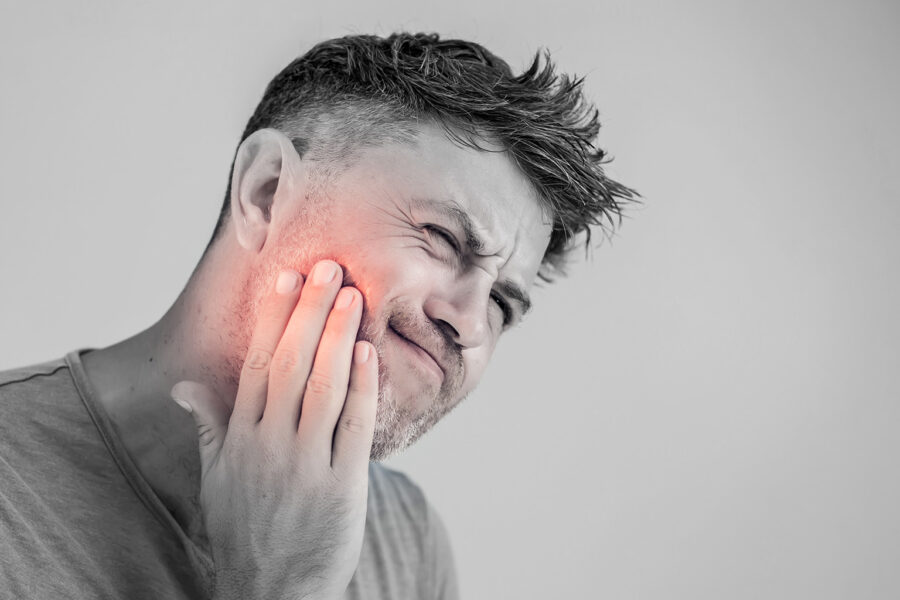 man holding his jaw in pain