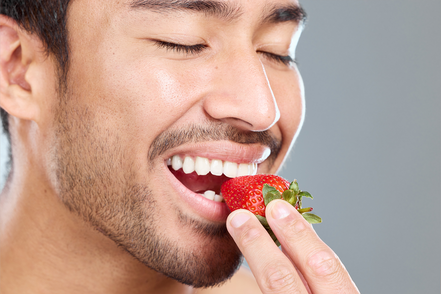 man eating a strawberry