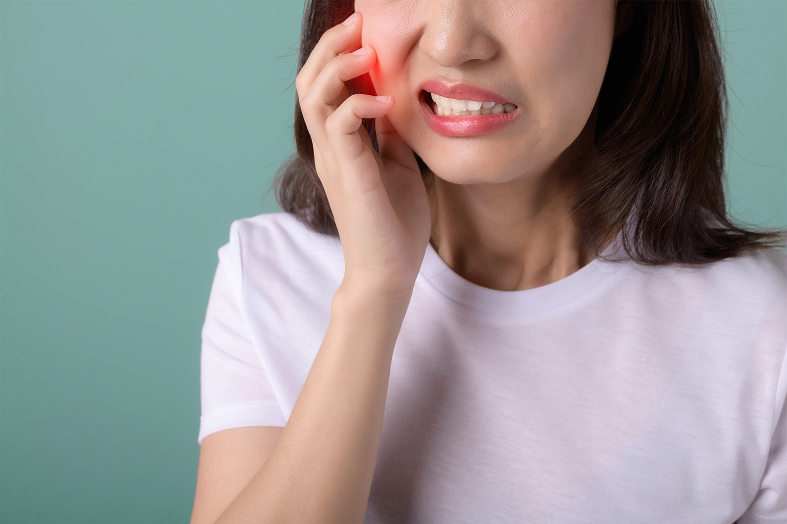 woman holding her cheek in pain