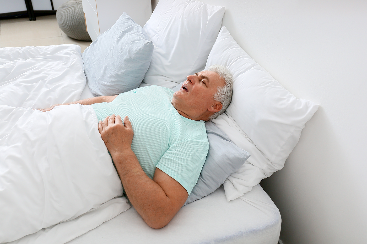 man sleeping on his back in bed