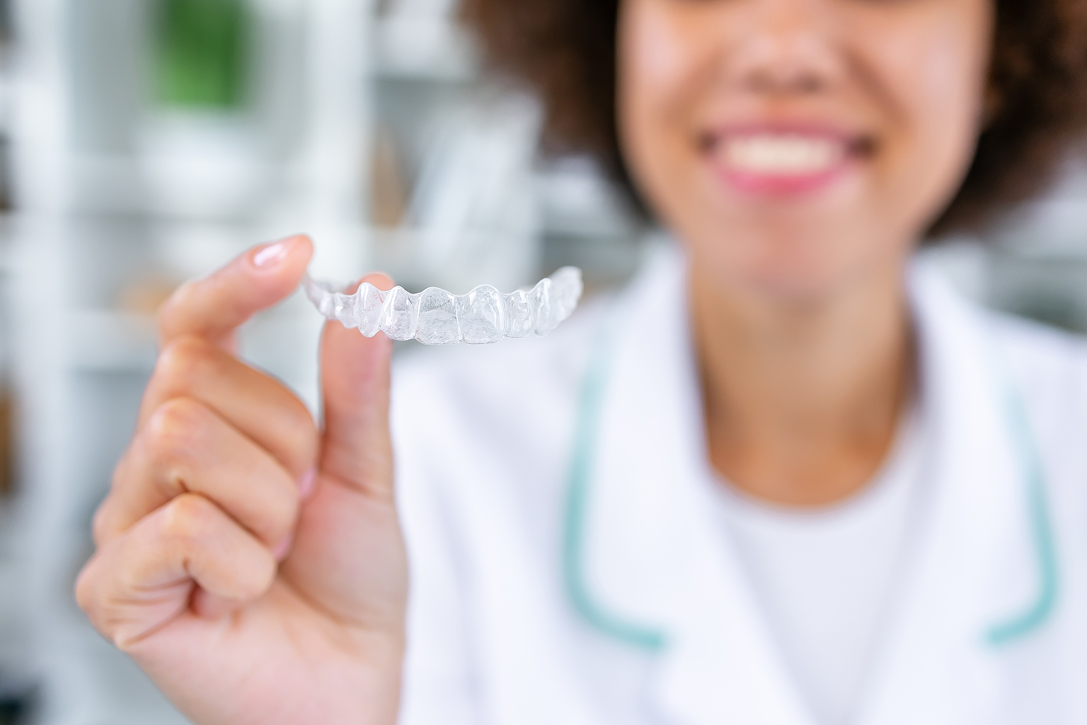 smiling woman holding clear alinger in her hand