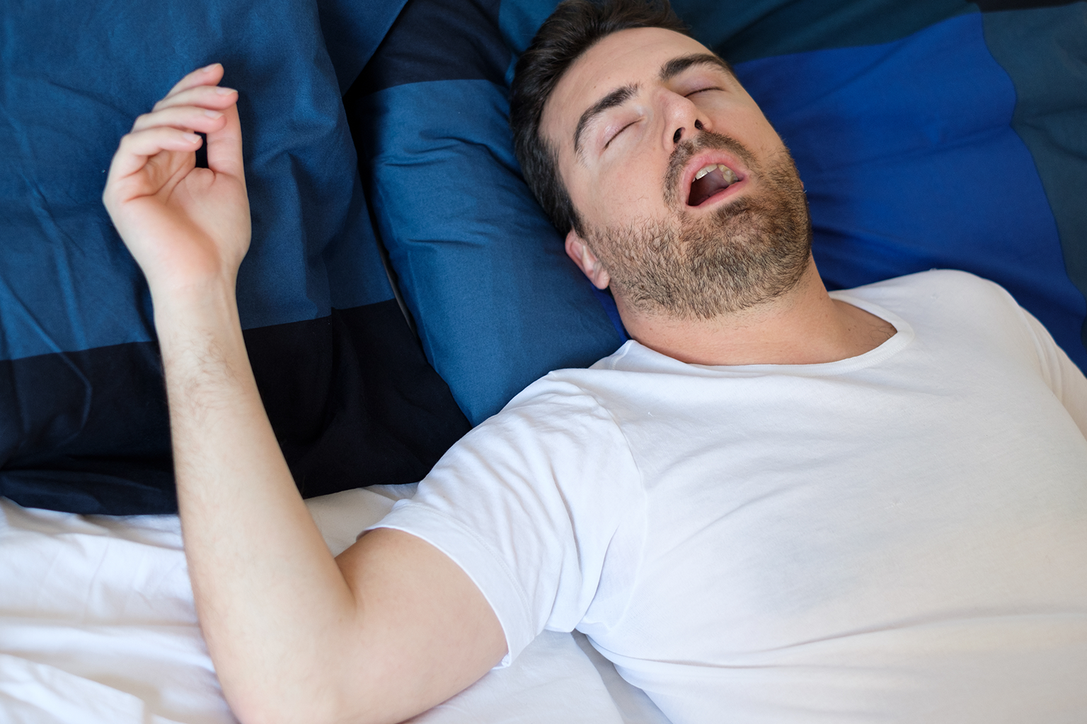 man sleeping on his back with his mouth open