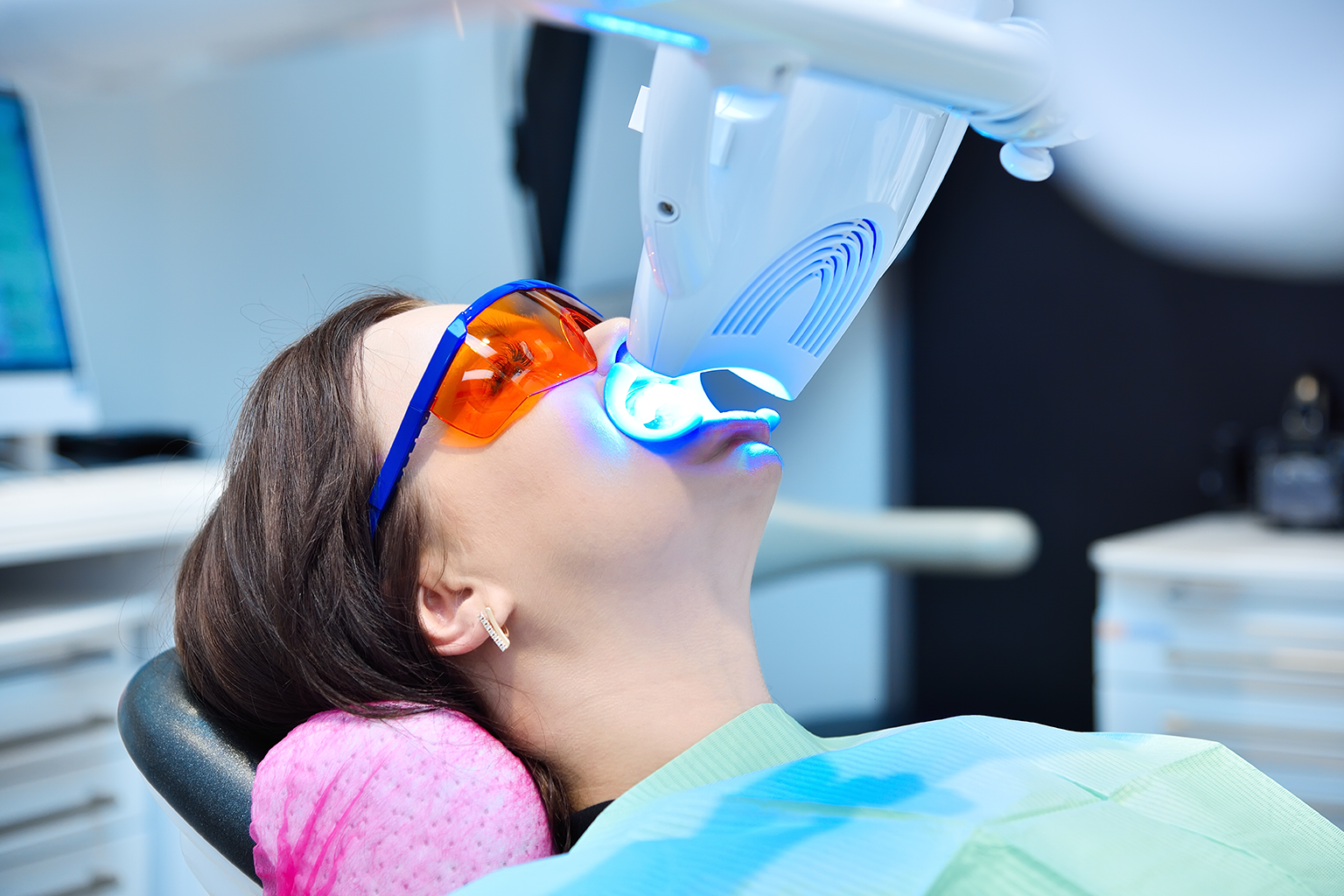 light shining on teeth of woman wearing orange glasses