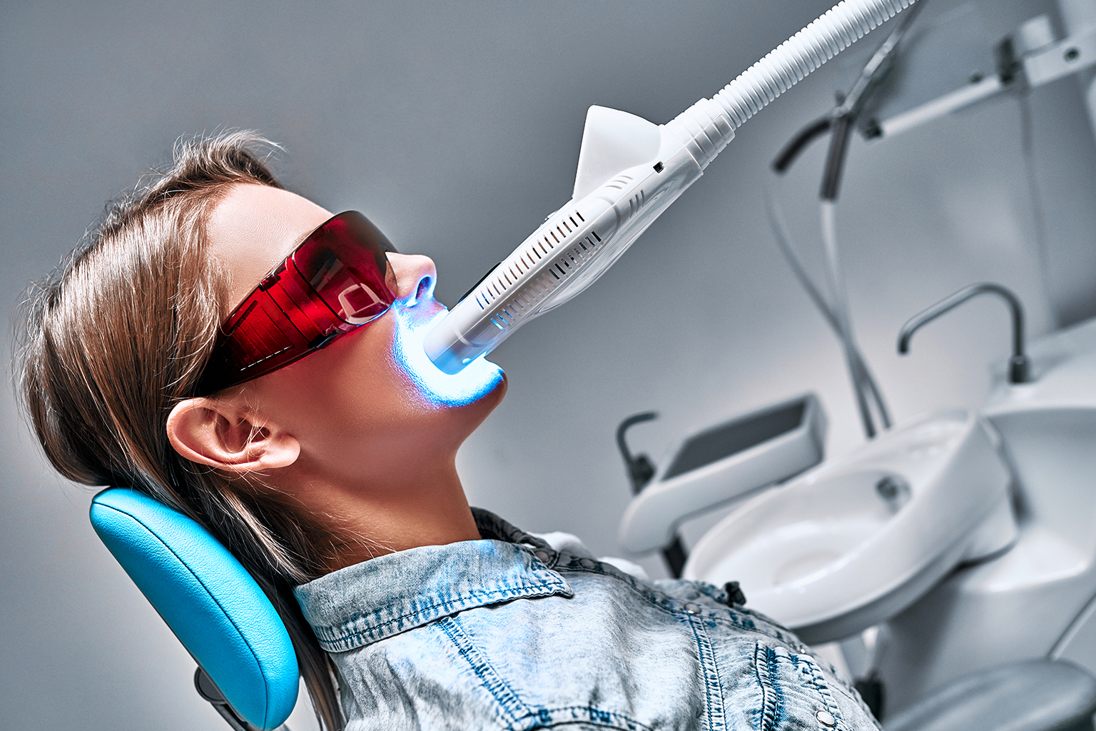 light shining on teeth of woman wearing orange glasses