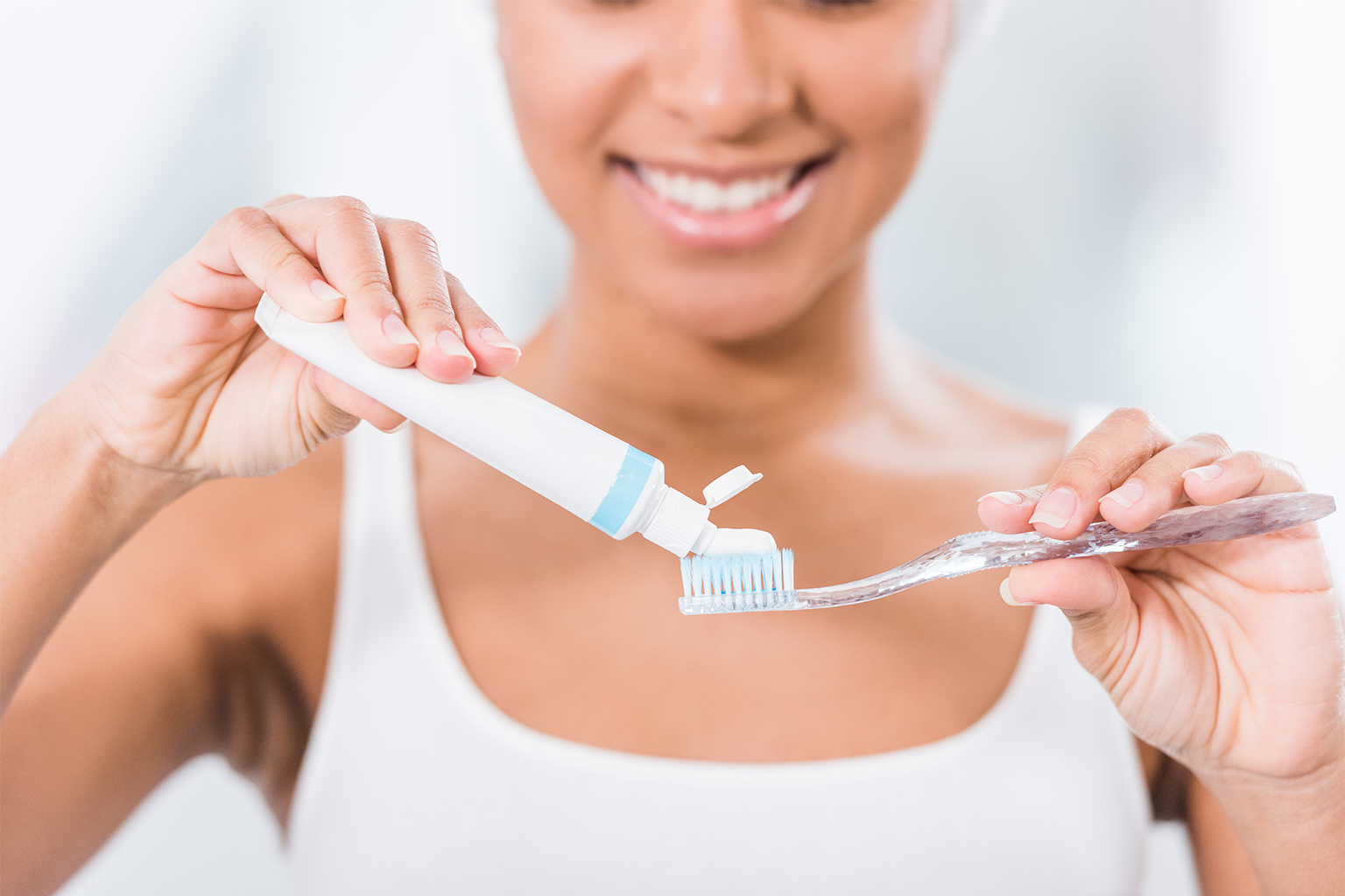 woman putting toothpaste on toothbrush