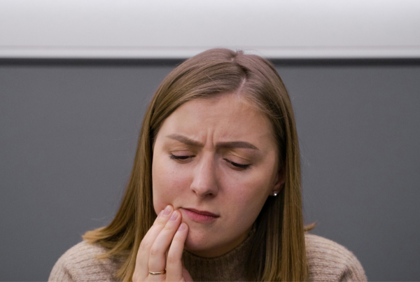 Woman holding her chin in pain.