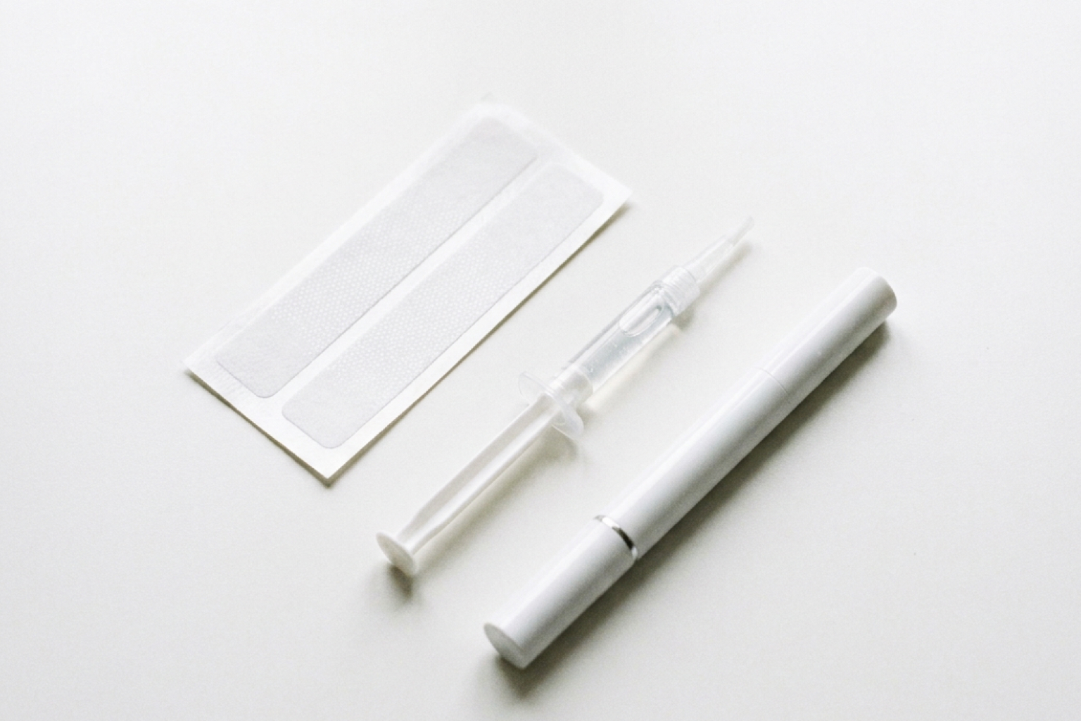 At-home teeth whitening kits including whitening strips, gel syringe, and whitening pen tool.