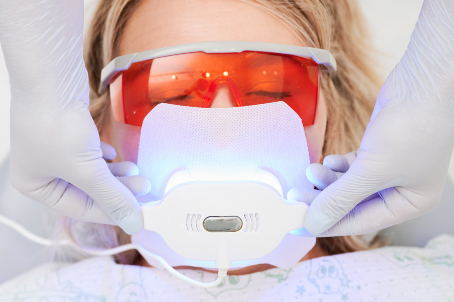 Patient wearing protective glasses during a professional in-office teeth whitening treatment.